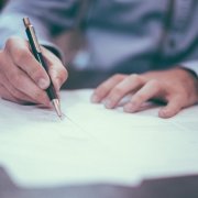 A photograph of a person writing out a report for the life care planning at GSO Health.